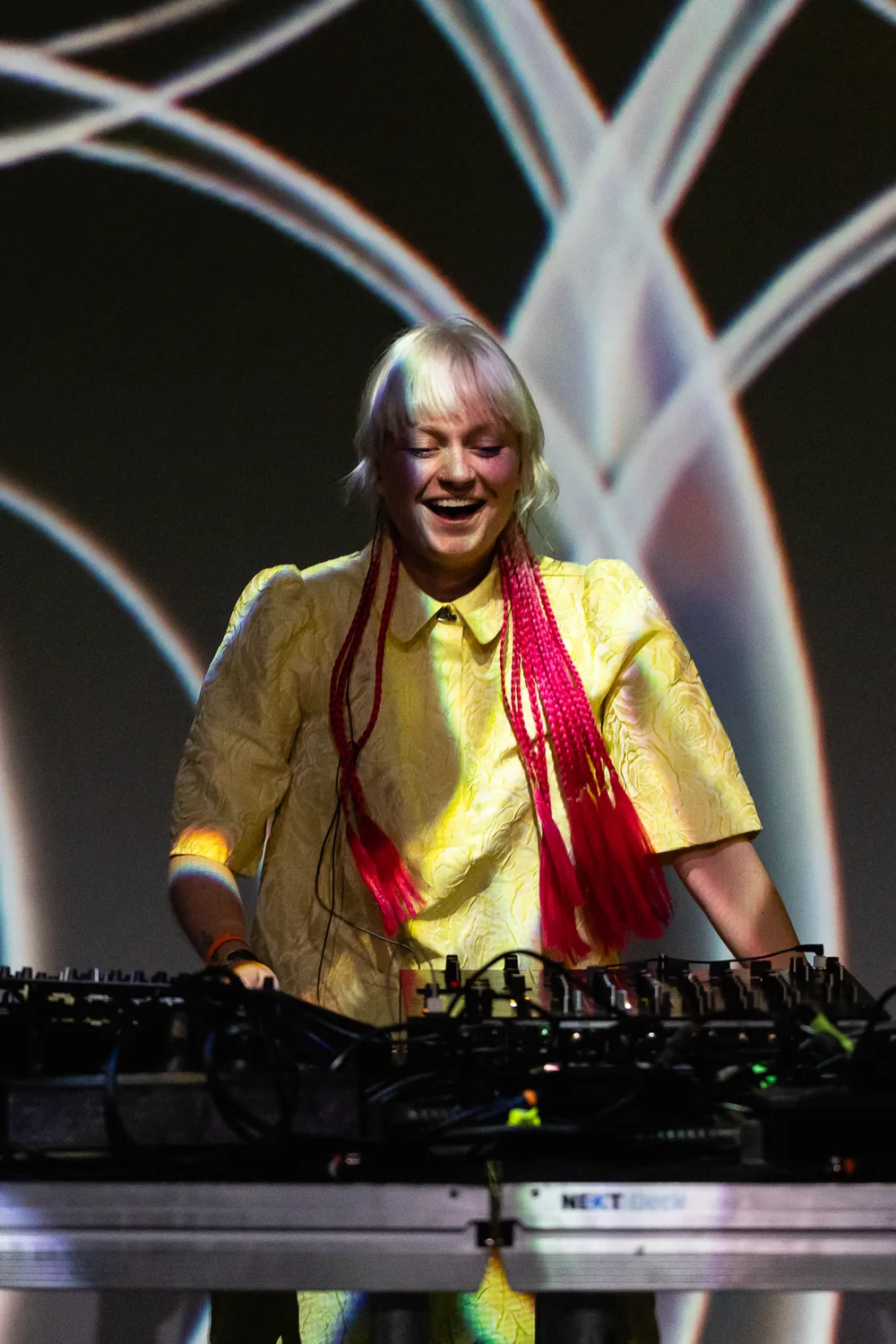 Nadia performing live in front of luminous branching visuals